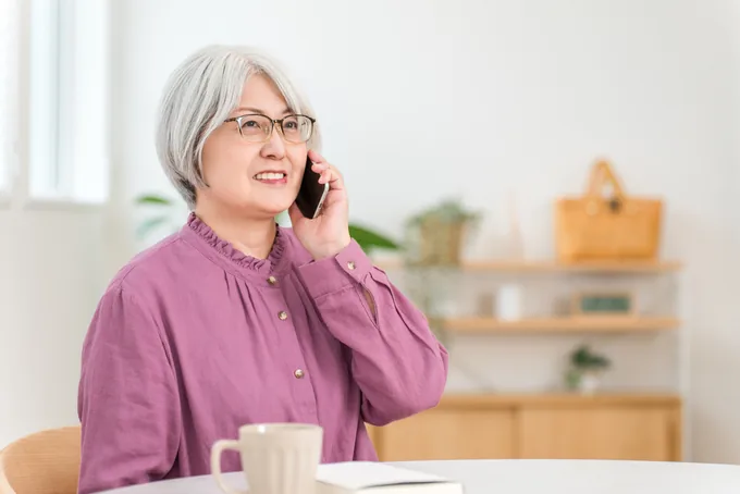 フリーダイヤルにお電話する中高年の女性